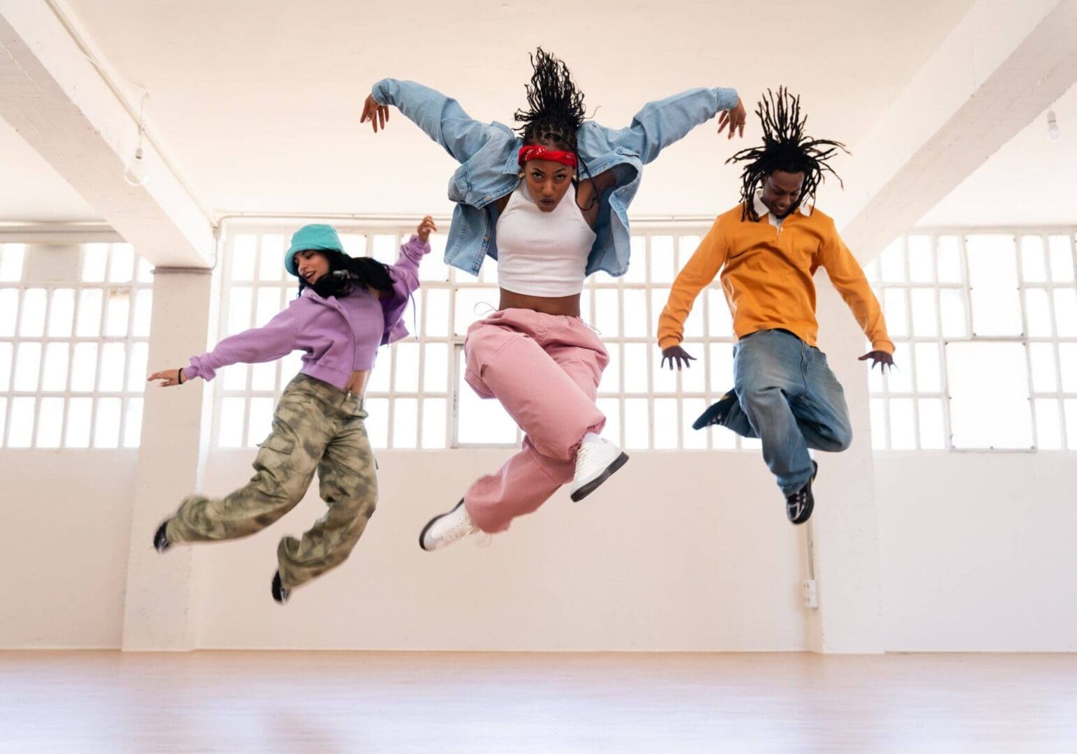 Energetic dance trio mid-air in a studio
