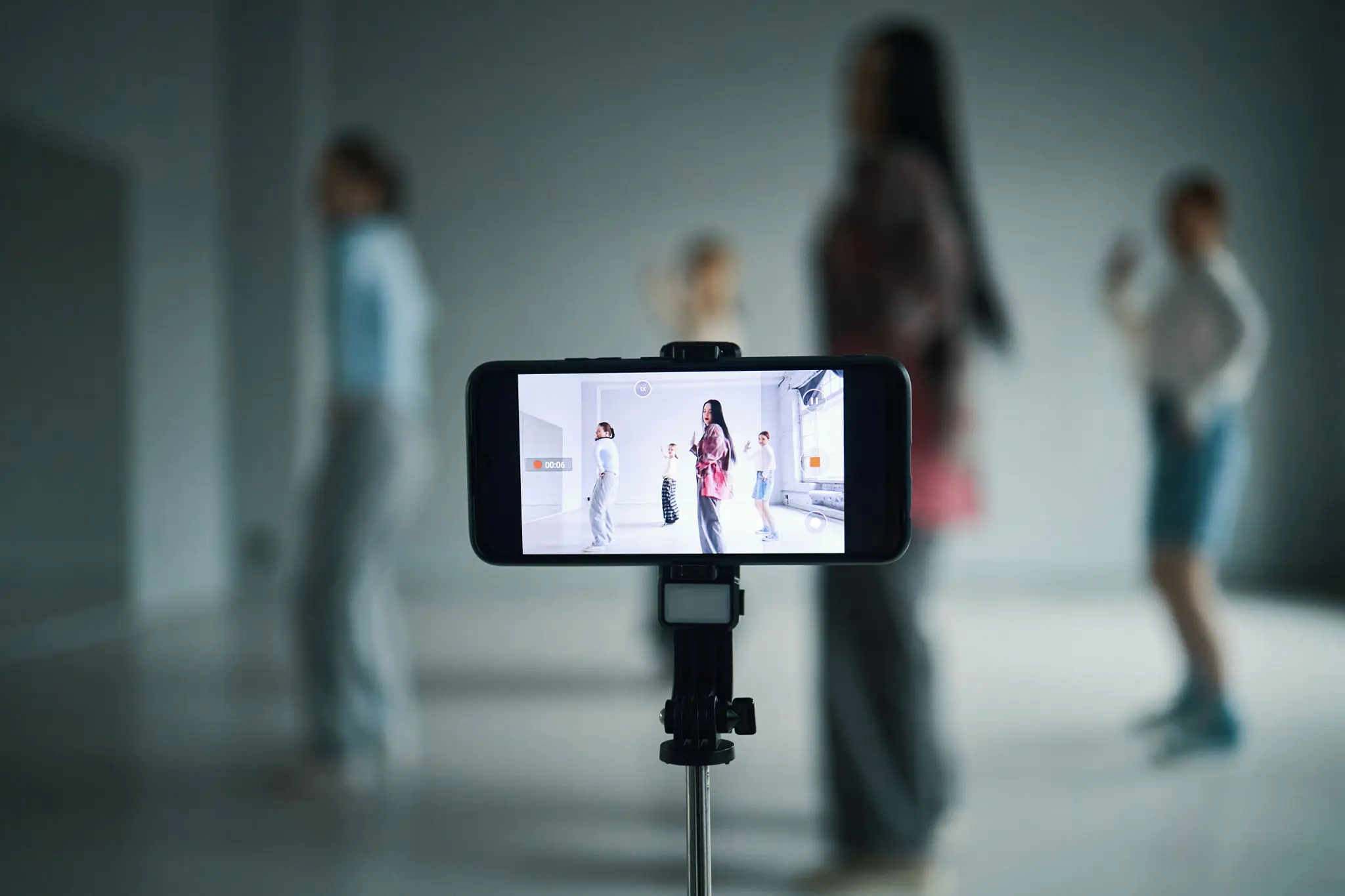 Smartphone capturing a fashion show with blurred models in the background.