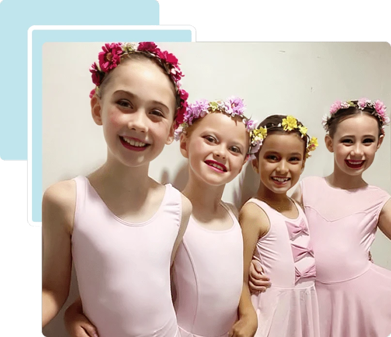 Four young girls dressed in pink ballet costumes with flower headbands.