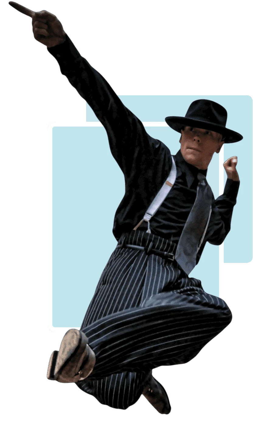 Man in black hat and pinstripe suit striking a dynamic pose.